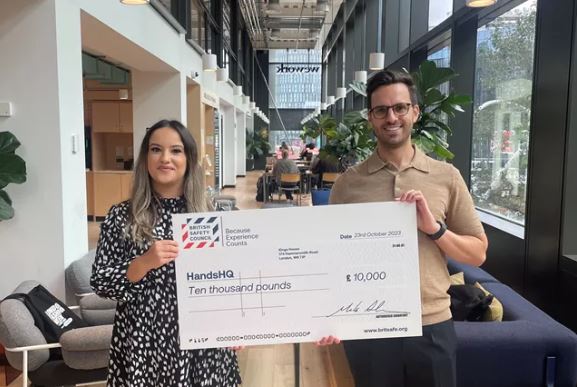 Jamie Carruthers, CEO and Co-founder of HandsHQ (right) receives their Keep Thriving award from Cat Mendes, Wellbeing Development Executive at British Safety Council (left).